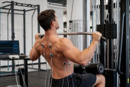 Athlete performing a lat pulldown with EMG electrodes to test back muscle activation