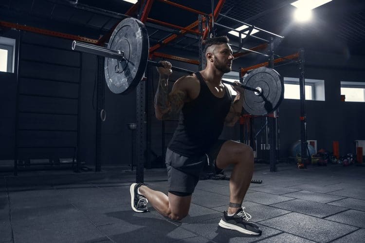 Athlete Practicing Lunges In Gym With Barbell