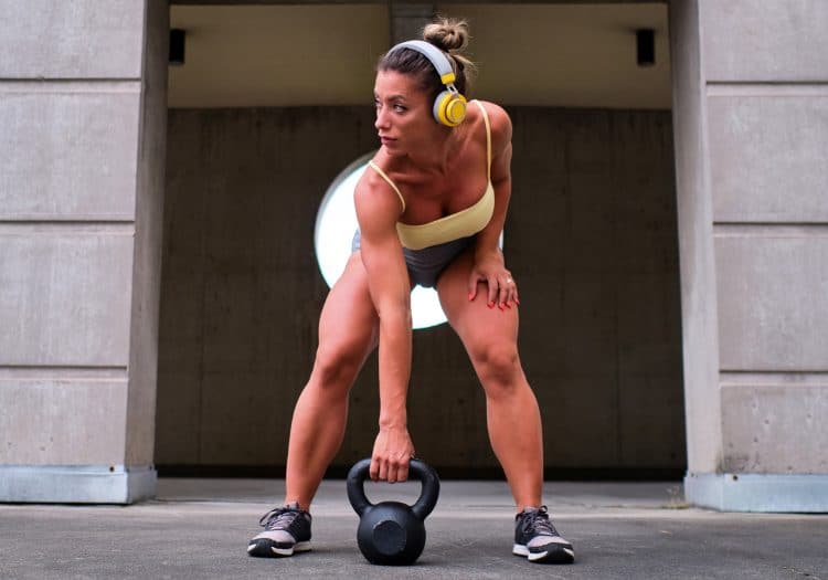 Woman Lifting Kettlebell With Headphones