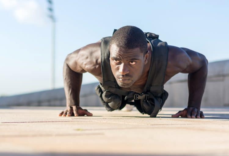 Muscular Man Doing Weighted Vest Push Ups