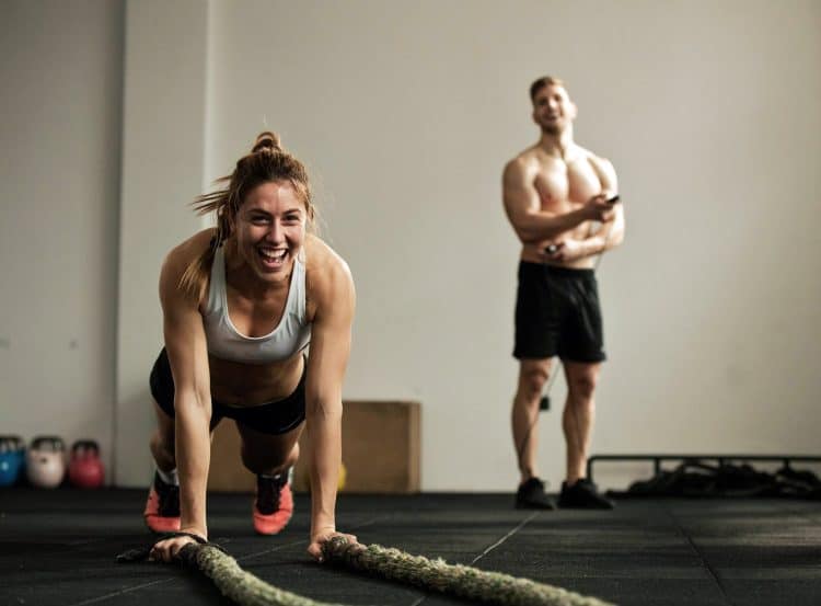 Crossfit Female Athlete Doing Pushups While Exercising With Battle Rope