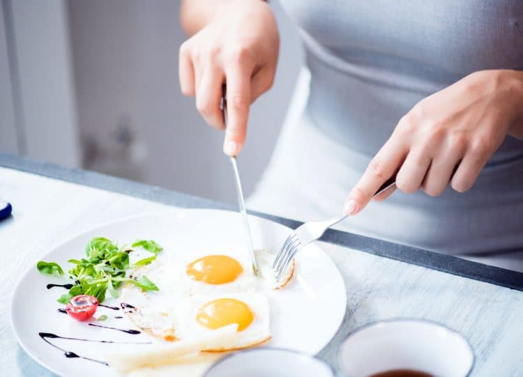 Woman Eating Fried Eggs