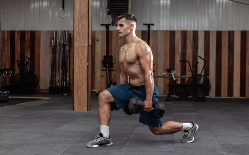 Man Doing Lunges With Heavy Dumbbells