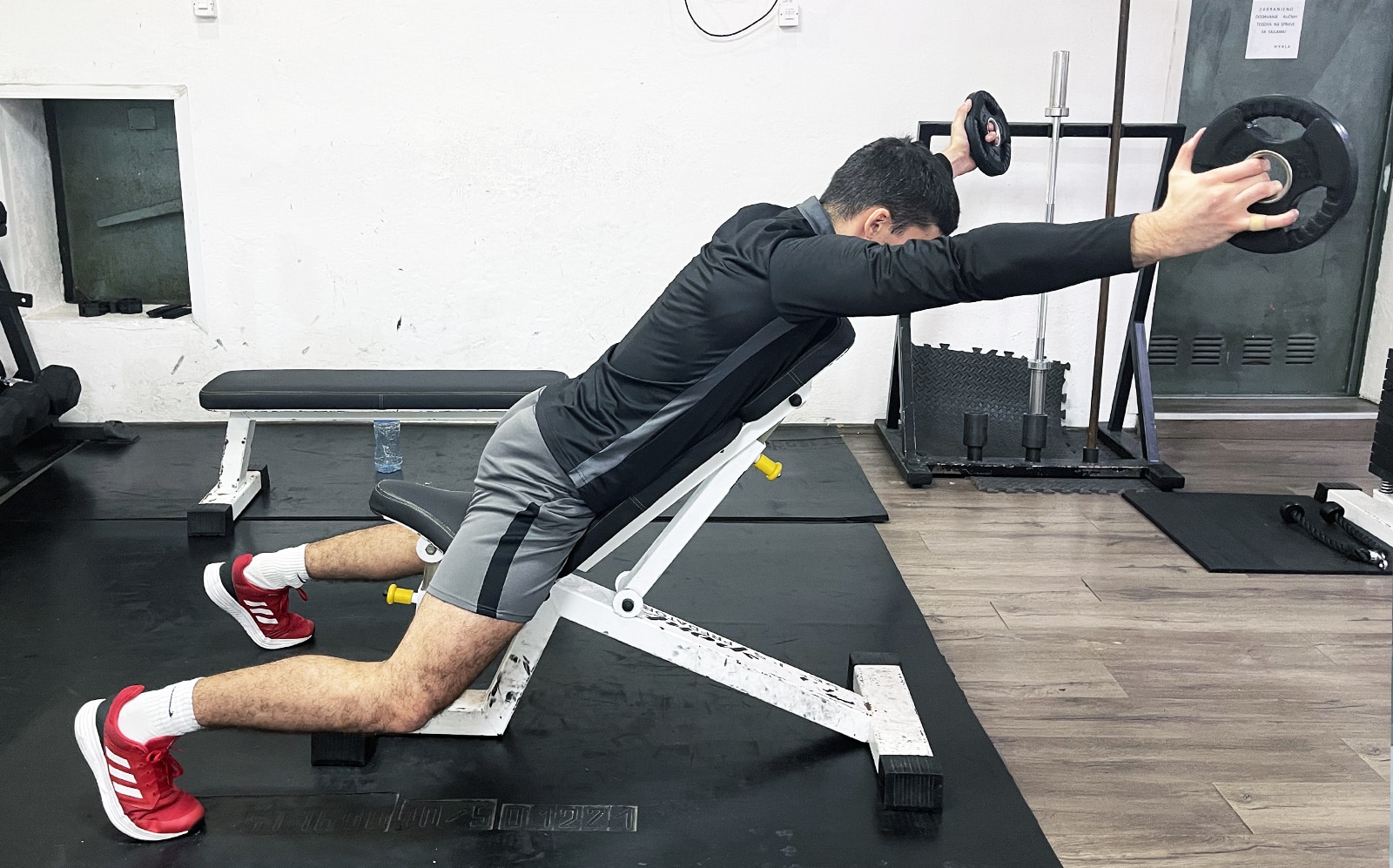 Incline Bench Plate Raise - Muscle & Fitness