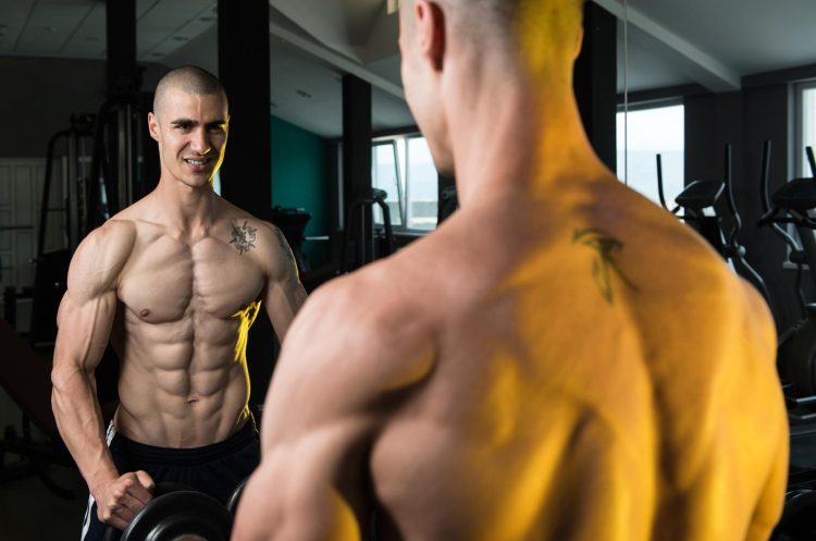 Man Flexing Front Of A Mirror