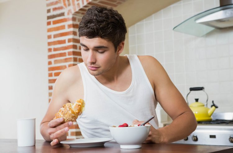Man Eating Croissant In Breakfast