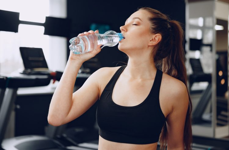 Woman Drinking Water In A Gym