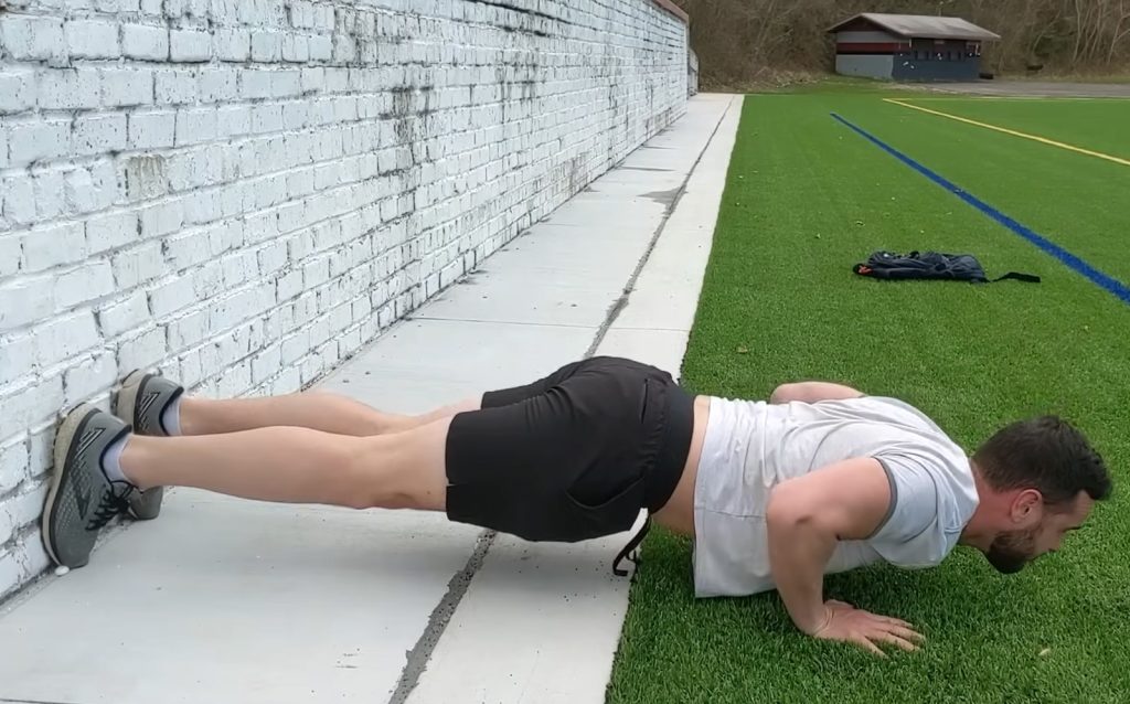 Wall-braced Mike Tyson push-up setup