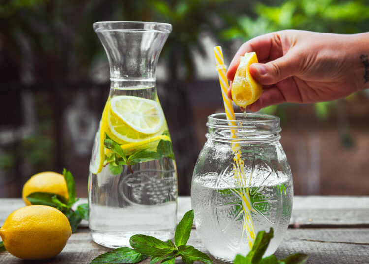 Squeezing Lemon Into A Glass Jar