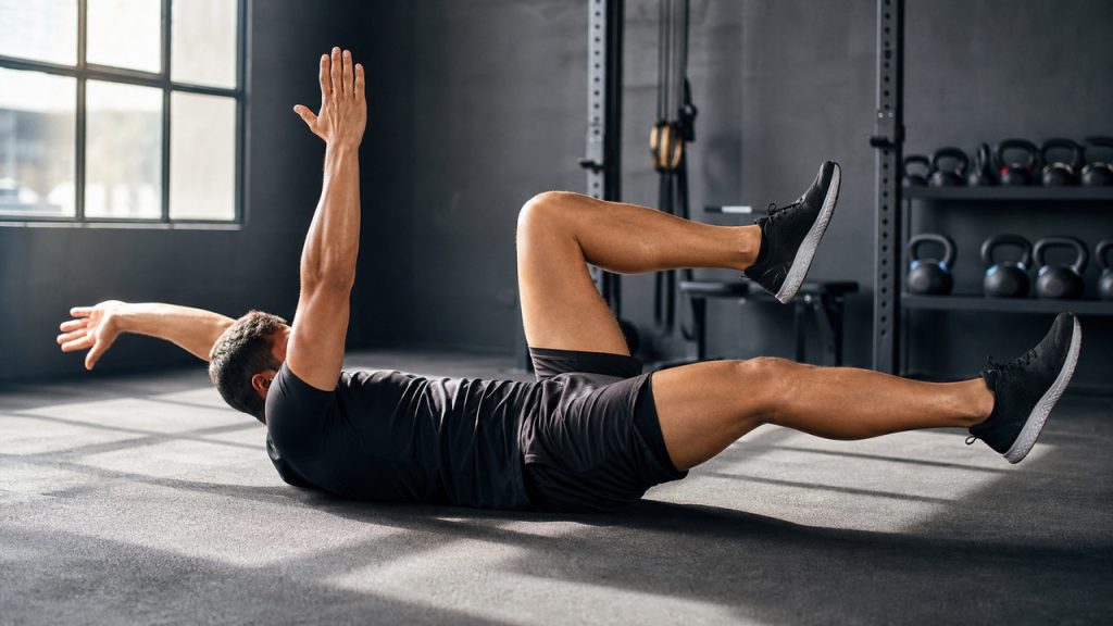 Athlete doing a controlled core exercise in a gym