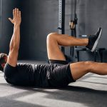Athlete doing a controlled core exercise in a gym