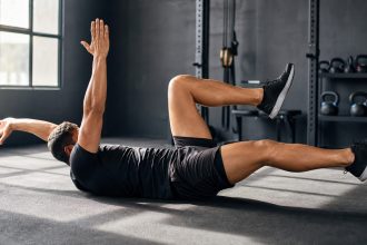 Athlete doing a controlled core exercise in a gym