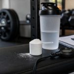 Unbranded shaker, scoop, stopwatch, training log, and dumbbells for beta-alanine evidence