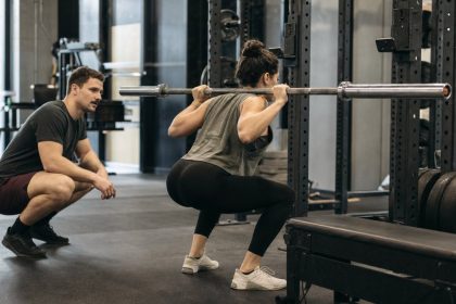 Coach watching a lifter set up for a safe squat with a rack and box nearby