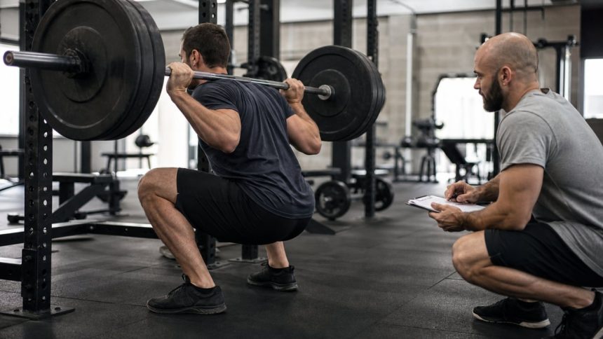 Coach-supervised barbell squat biomechanics session in a modern strength gym