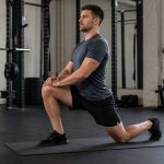 A half-kneeling hip mobility setup helps lifters prepare for better squat and lunge positions.