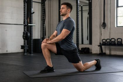 A half-kneeling hip mobility setup helps lifters prepare for better squat and lunge positions.