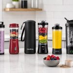 Portable blender beside a protein shake and gym bag