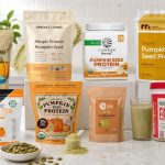 Pumpkin seed protein powder beside a smoothie, oats, and whole pumpkin seeds