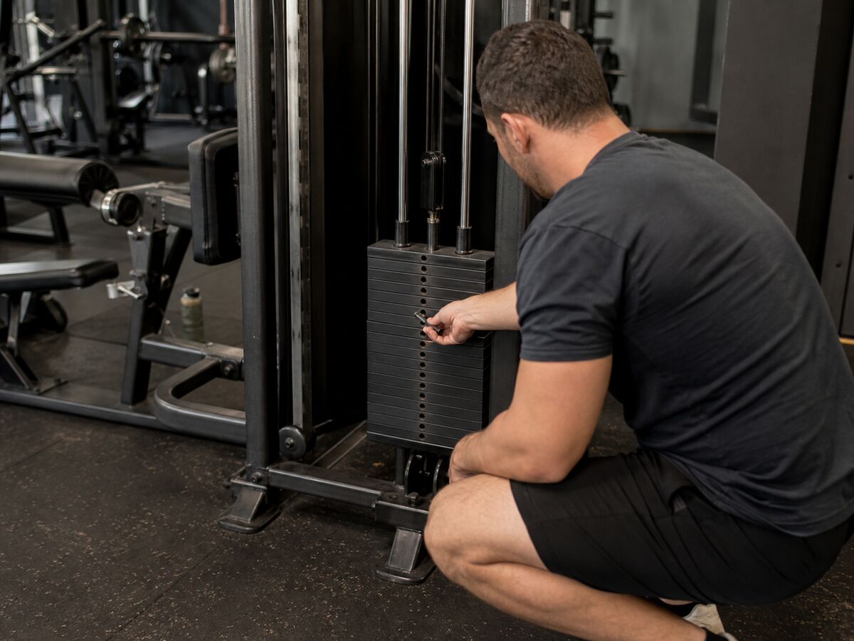 Lifter adjusting a selector pin on a machine weight stack