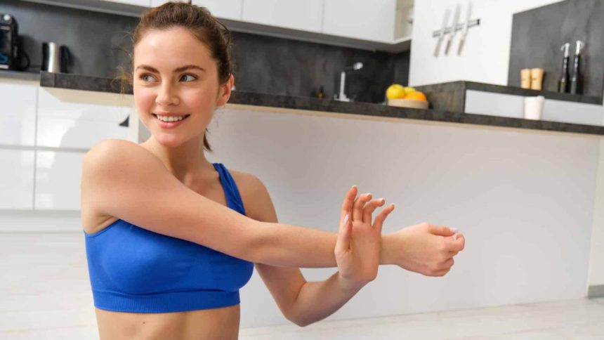 Person stretching indoors beside a kitchen counter