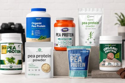 Eight pea protein powder bags arranged with a blender, oats, and berries in a bright fitness kitchen