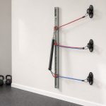 Resistance band wall anchor rails and fixed hooks installed in a bright home gym