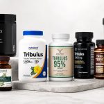Tribulus terrestris supplement bottles arranged beside a training notebook and measuring scoop