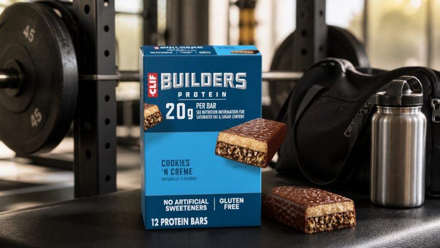 CLIF BUILDERS Cookies N Creme protein bars beside gym equipment