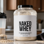 NAKED Whey five-pound tub beside a shaker, oats, banana, and gym towel