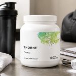 Thorne Creatine 90-serving tub beside a shaker and training gear