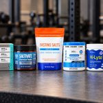 Seven branded fasting electrolyte powder packages on a gym counter