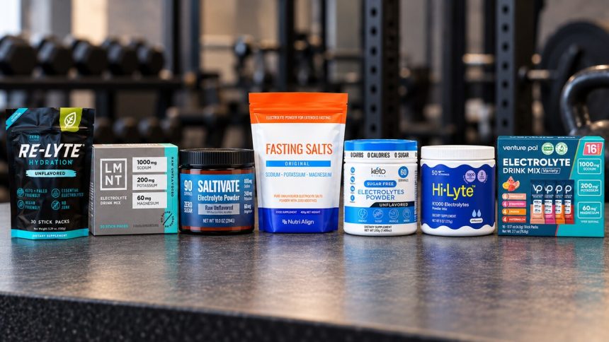 Seven branded fasting electrolyte powder packages on a gym counter