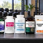 Seven branded magnesium taurate supplement packages on a gym counter