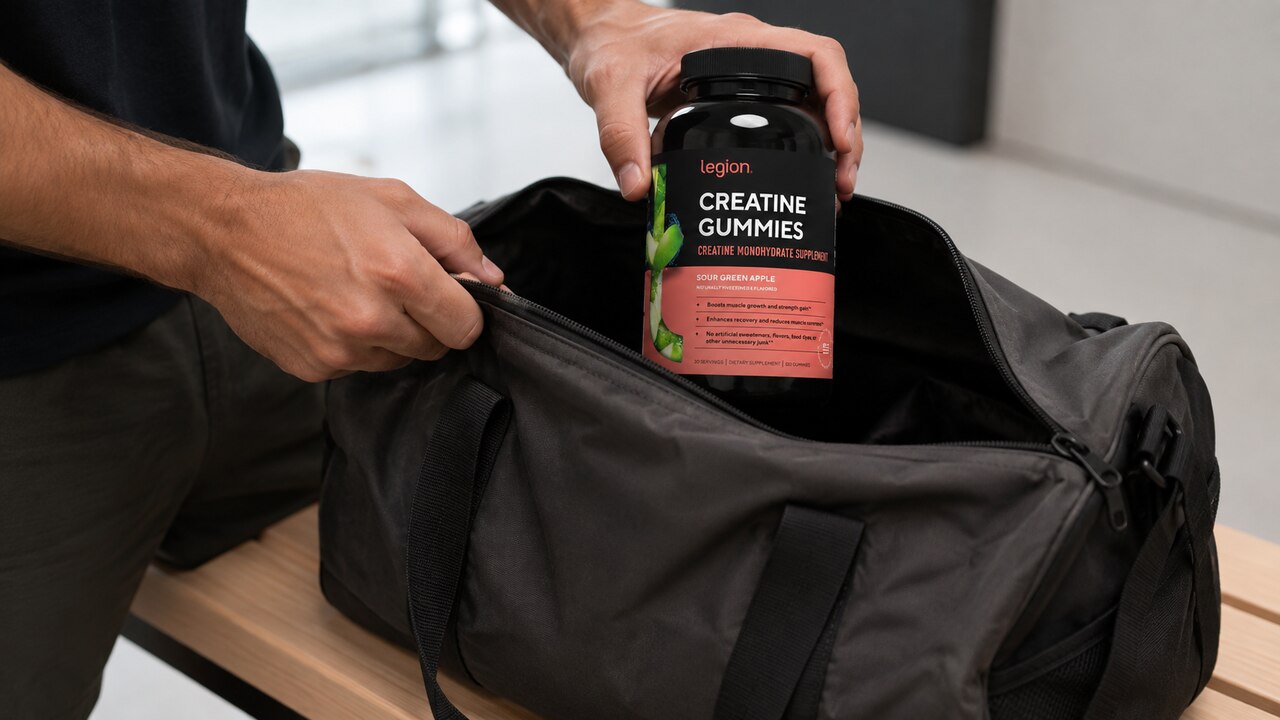 Legion Green Apple creatine gummies bottle being placed in a gym bag