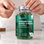 Hands opening a WeightWorld Super Greens Gummies bottle