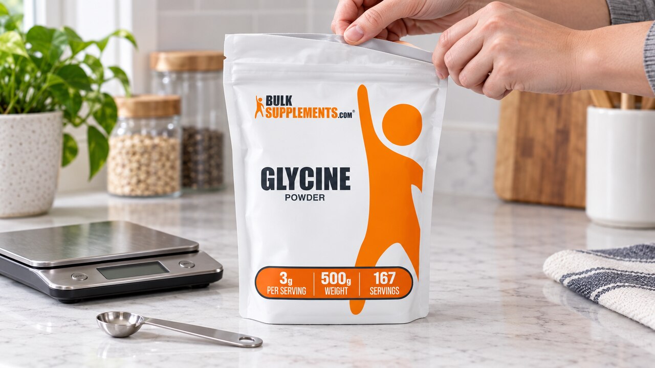 BulkSupplements Glycine Powder 500 g pouch beside a scale and teaspoon
