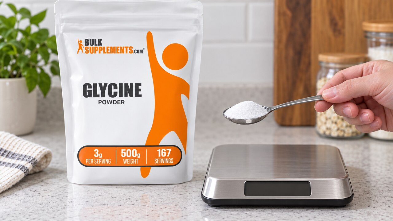 Spoon of white powder above a scale beside the BulkSupplements Glycine pouch