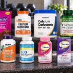 Ten calcium carbonate supplement packages arranged on a metal workout bench.