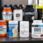 Ten protein powder packages for the older-adult comparison arranged on a gym bench with visible labels