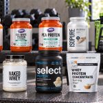 Ten stevia-free protein powder packages on a gym bench with visible manufacturer labels