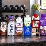 Ten chocolate protein drinks with 30g to 45g protein shown together on a gym bench